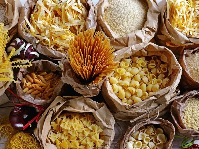 Bronzegezogene italienische Pasta mit rauer Oberfläche auf Holzbrett