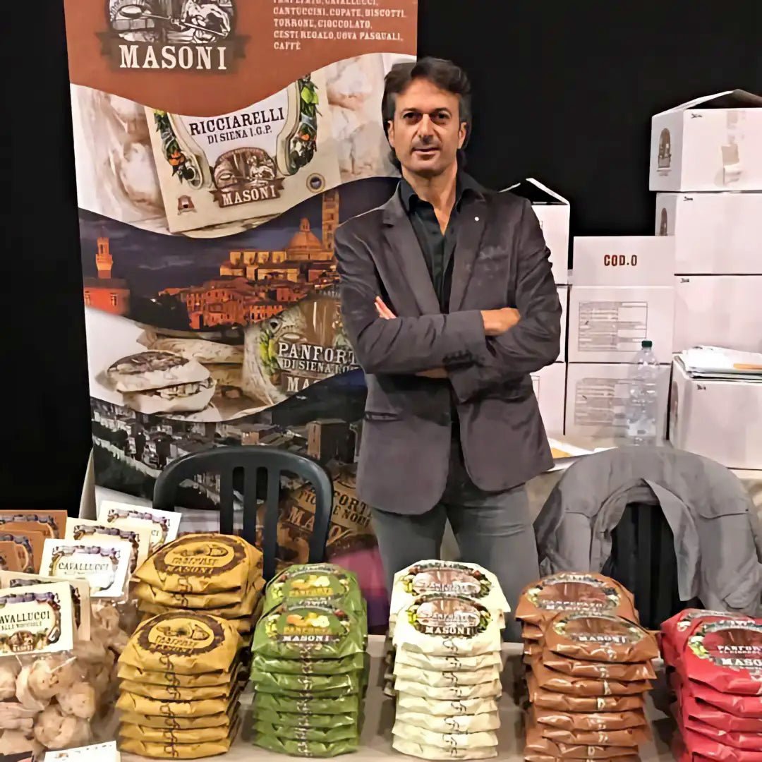 Massimiliano Masoni mit Produkten an einem Messestand - OLIPASO