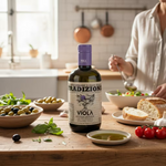 Stilleben mit einer Flasche Viola Tradizione Olivenöl und Basilikum, Oliven, Weißbrot, Tomaten und Oliven